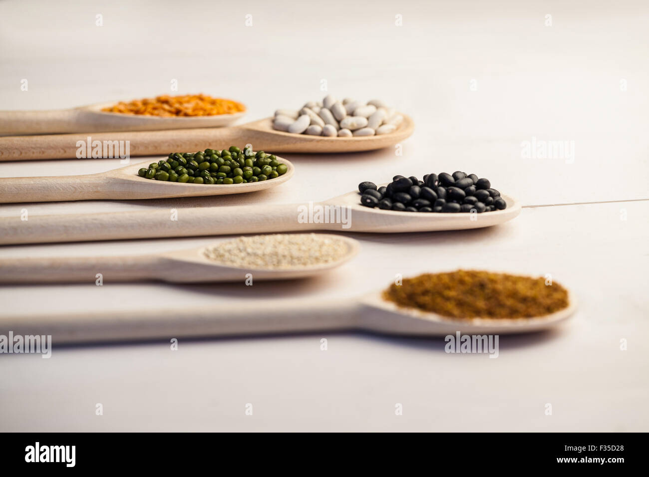 Wooden spoons of pulses and seeds Stock Photo