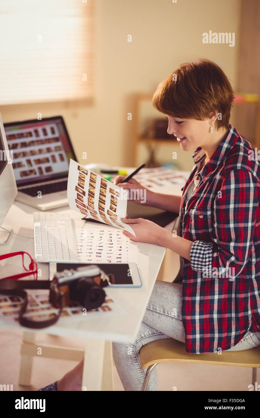 Smiling photographer looking pics at her desk Stock Photo - Alamy