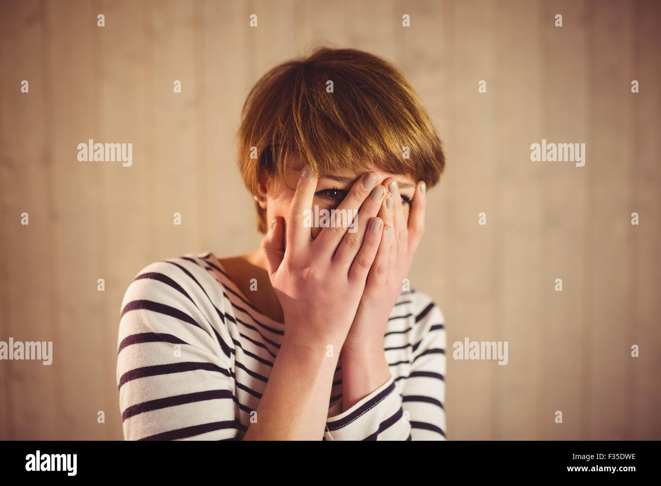 Pretty short hair woman hiding her face behind her hands Stock Photo