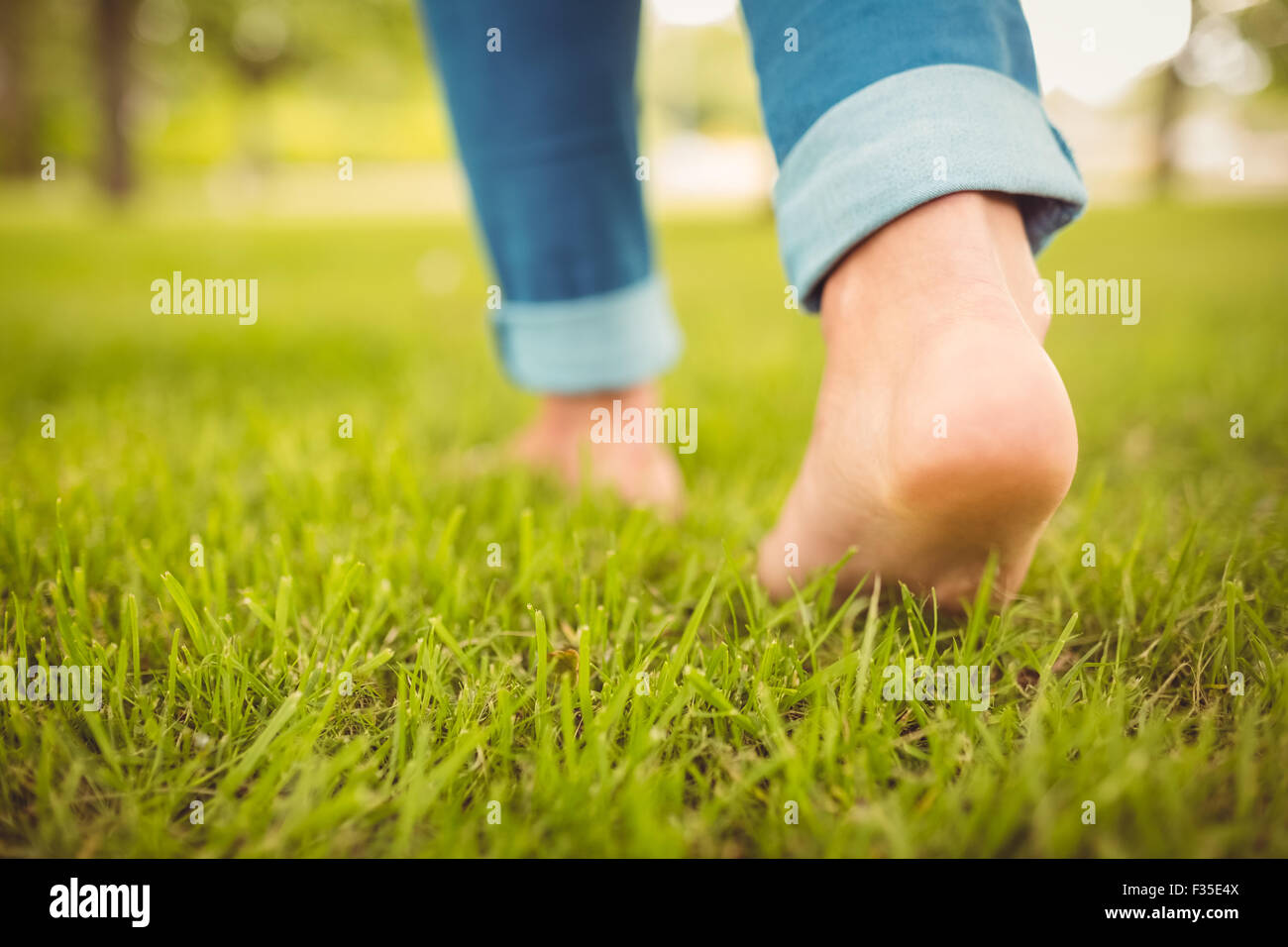 Low section of woman walking on grass Stock Photo