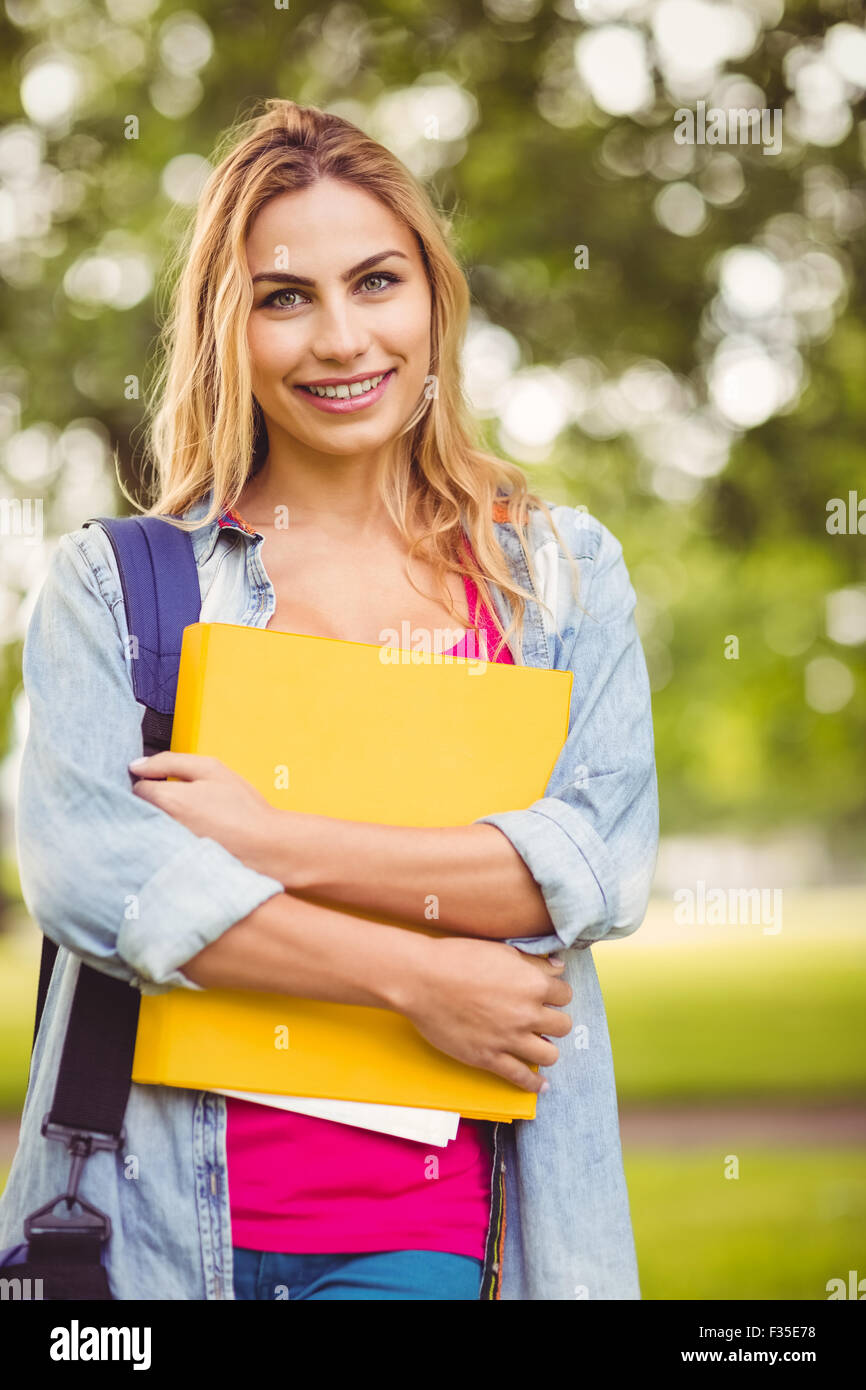 Portrait of smiling female student carrying bag and file Stock Photo ...