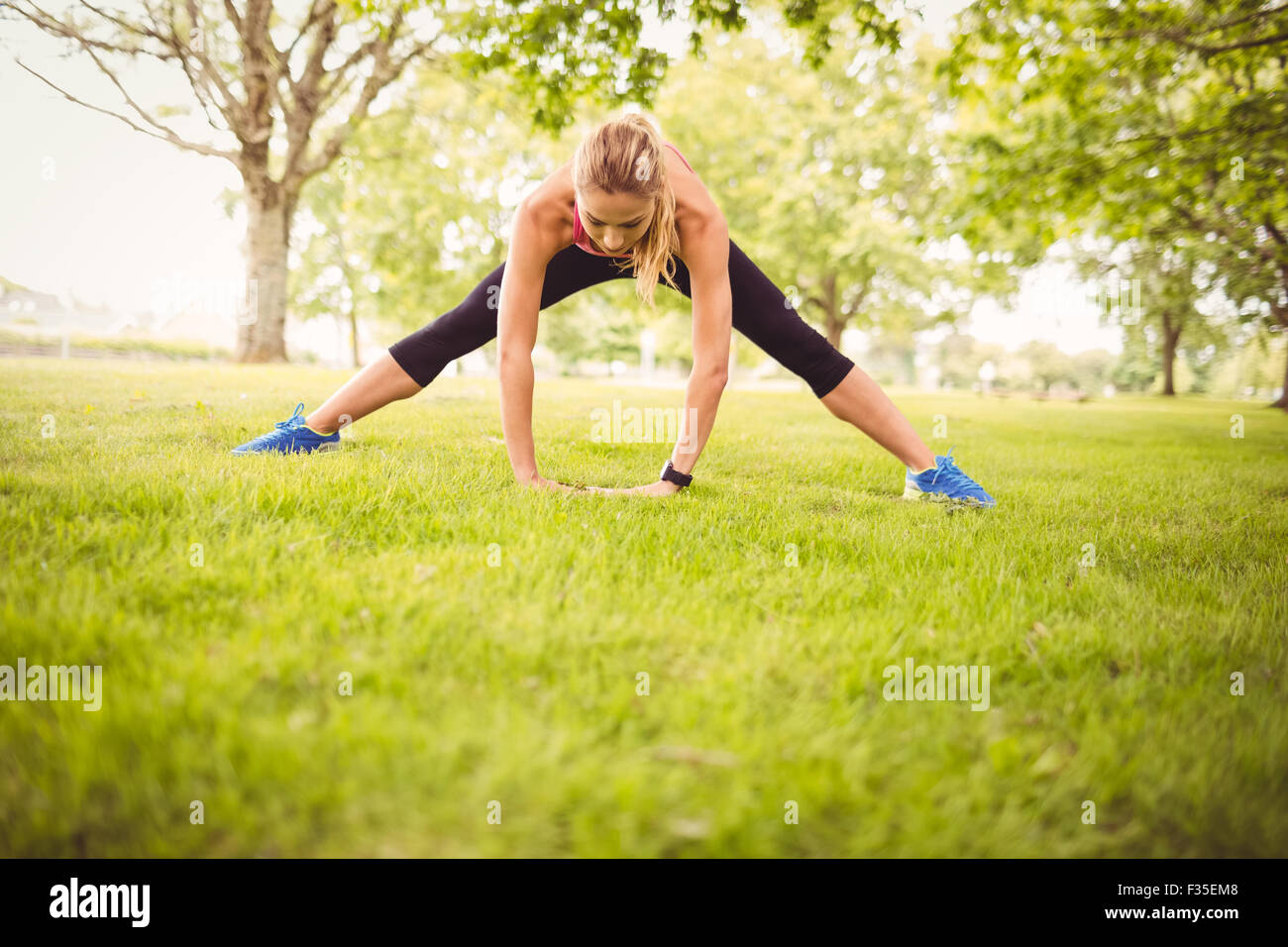 Fit woman exercising with stretching leg Stock Photo - Alamy