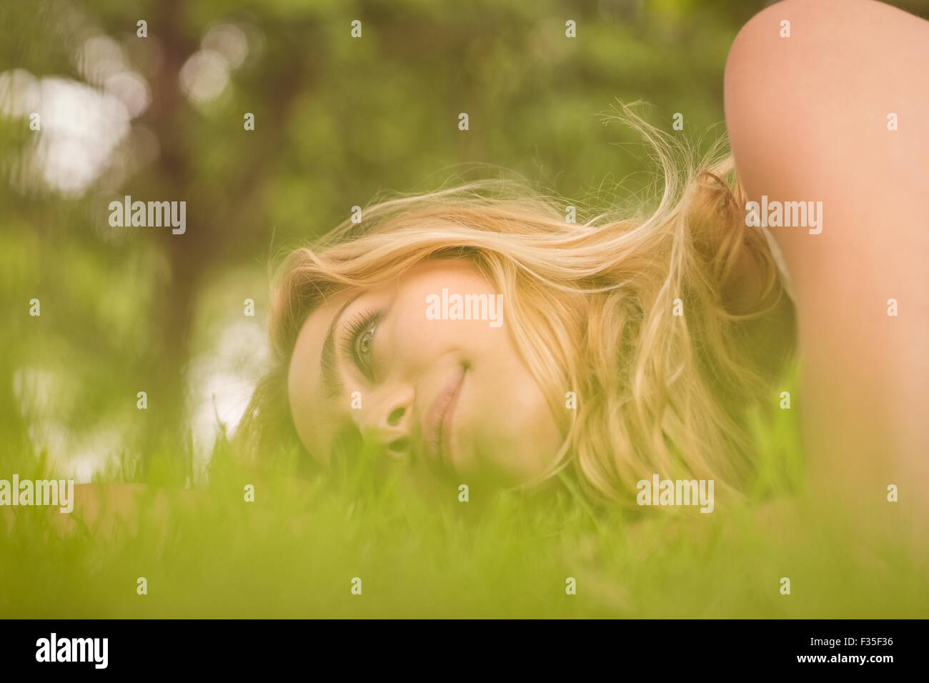 Side view of beautiful smiling woman looking away at park Stock Photo ...
