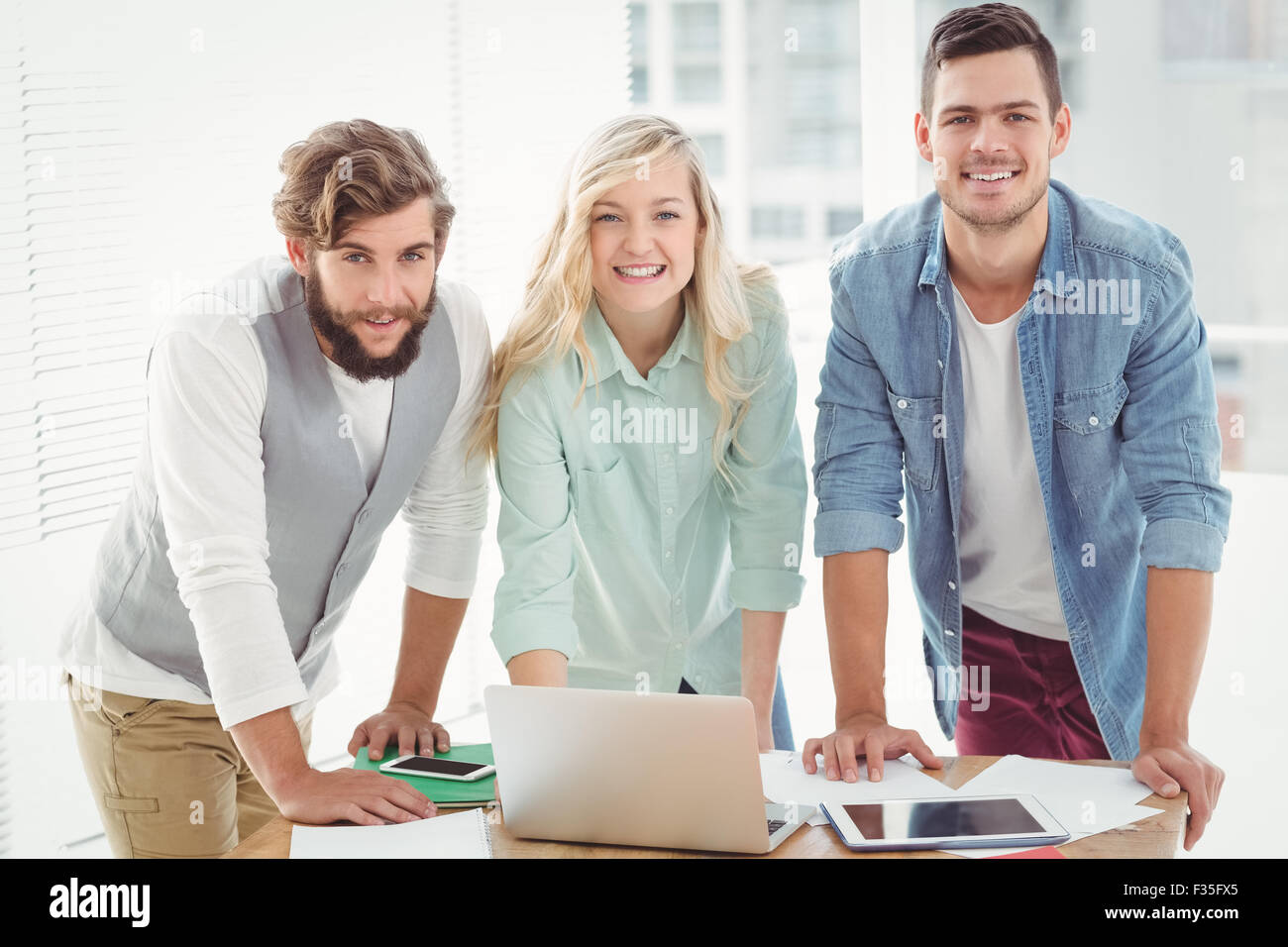 Portrait of smiling business people working Stock Photo - Alamy