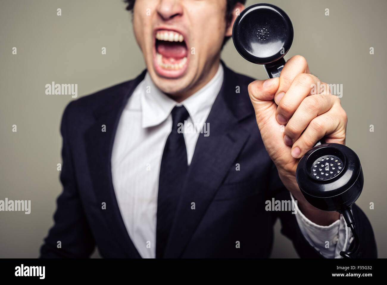 An angry young businessman is on the phone and screaming Stock Photo ...