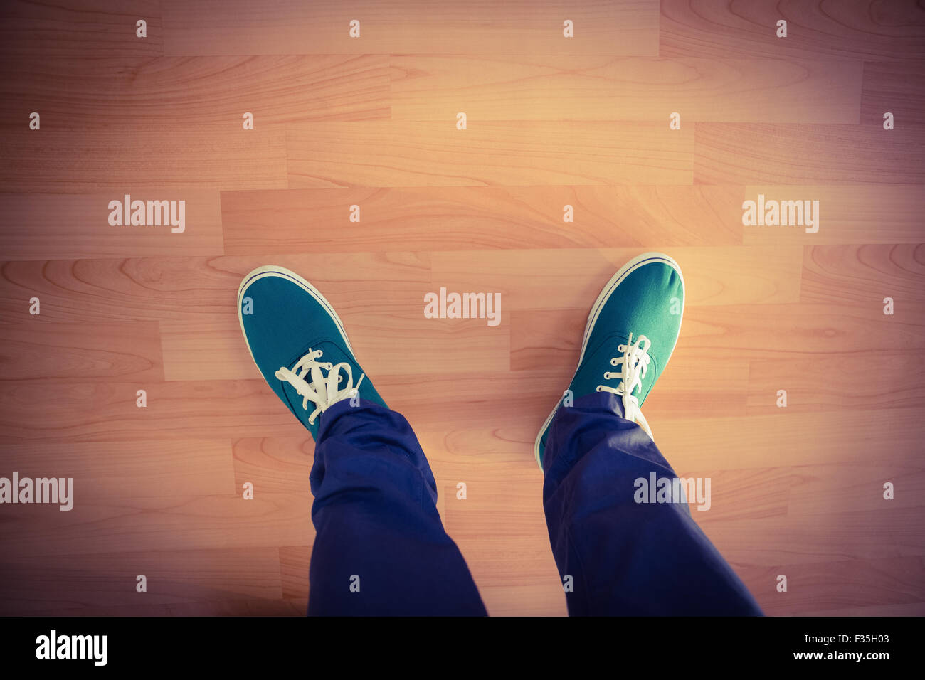 Man with canvas shoes on hardwood floor Stock Photo