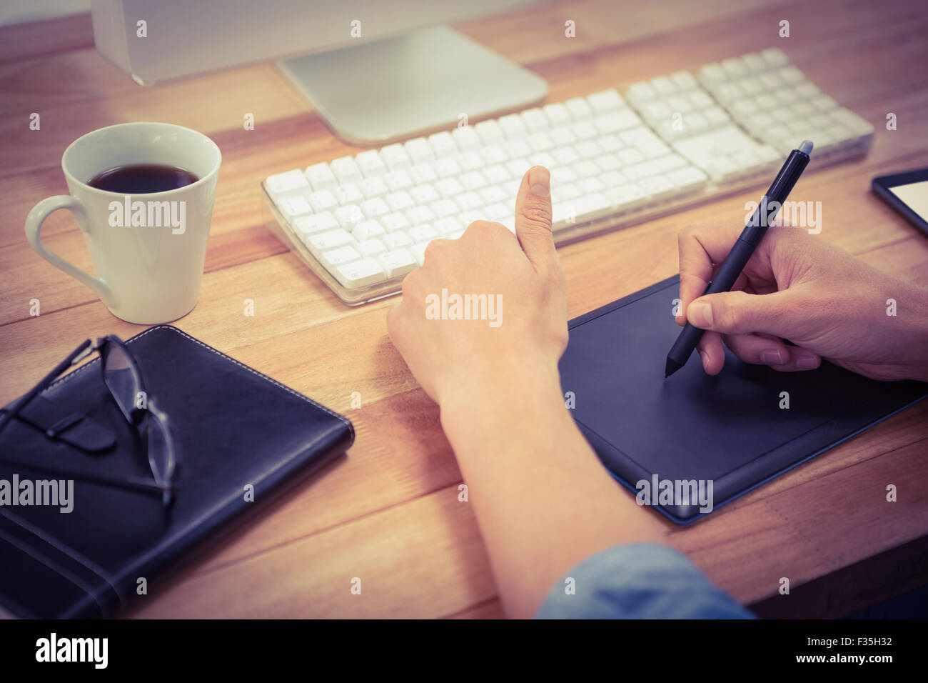 Hipster using graphics tablet on desk in office Stock Photo