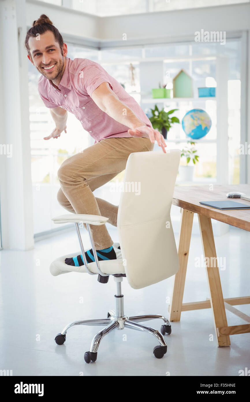 happy-businessman-standing-on-swivel-chair-F35HNE.jpg
