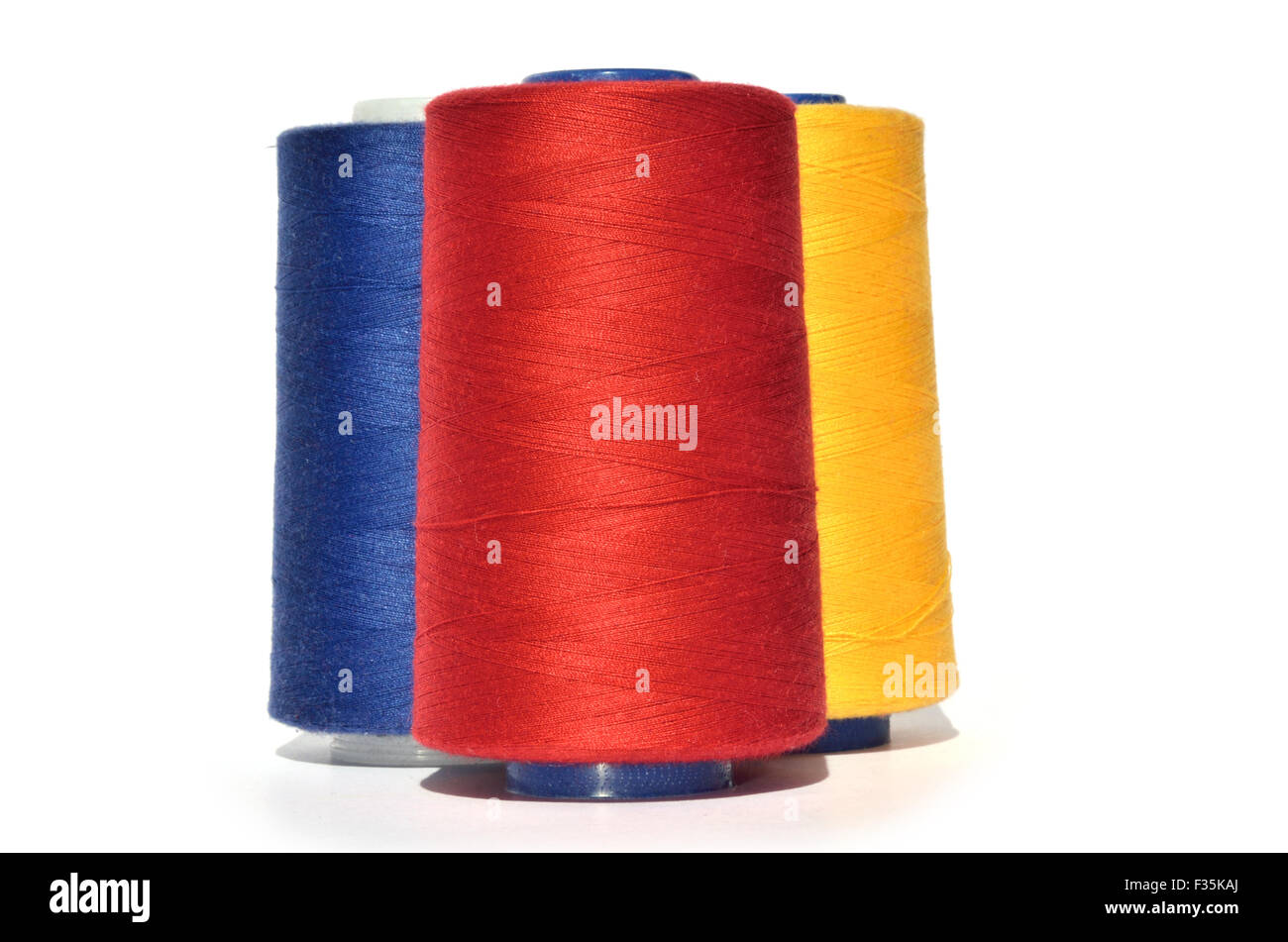 Reels of red, blue and yellow thread on white background Stock Photo ...