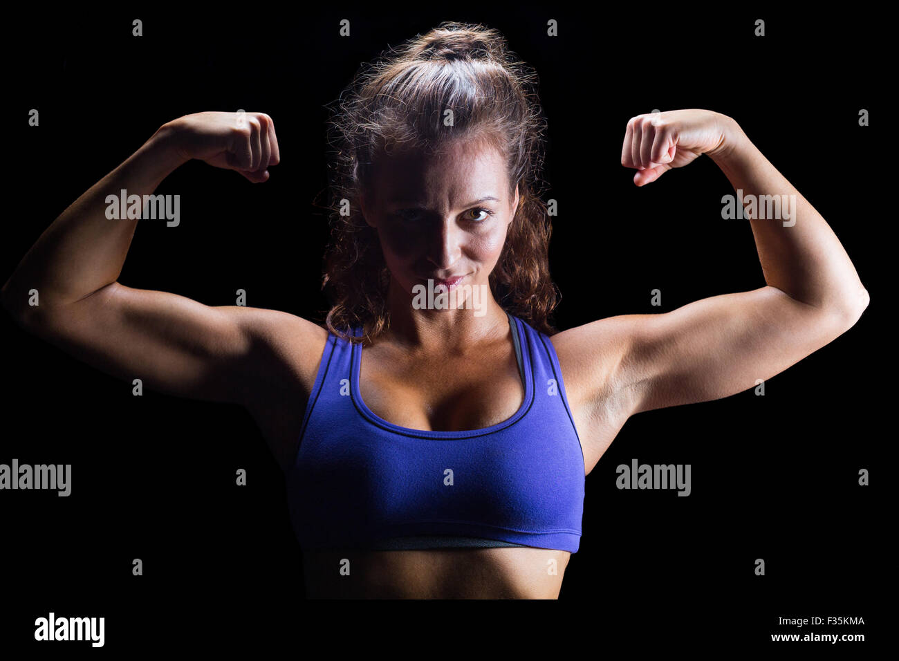 Portrait woman flexing bicep muscles hi-res stock photography and