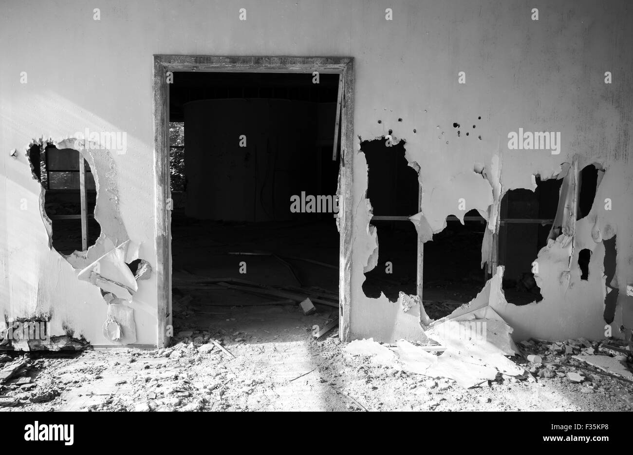 Abandoned building interior. Empty door and holes in wall. Black and white photo Stock Photo