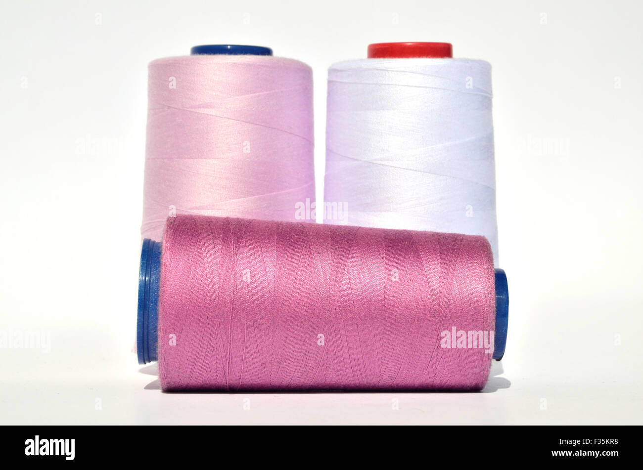 Reels of pink, pink and white thread on white background Stock Photo ...