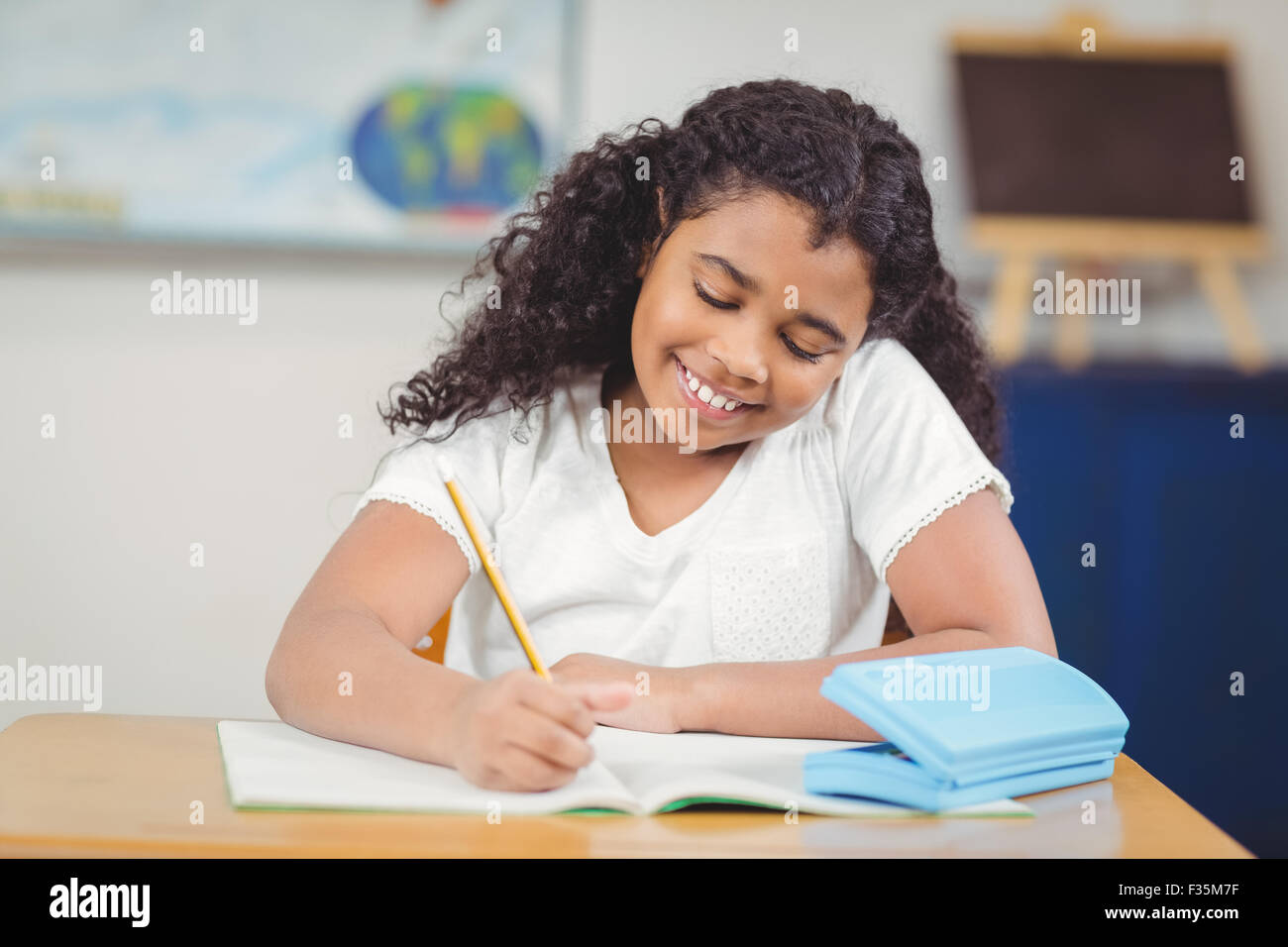 Cute pupil working at her desk in a classroom Stock Photo - Alamy