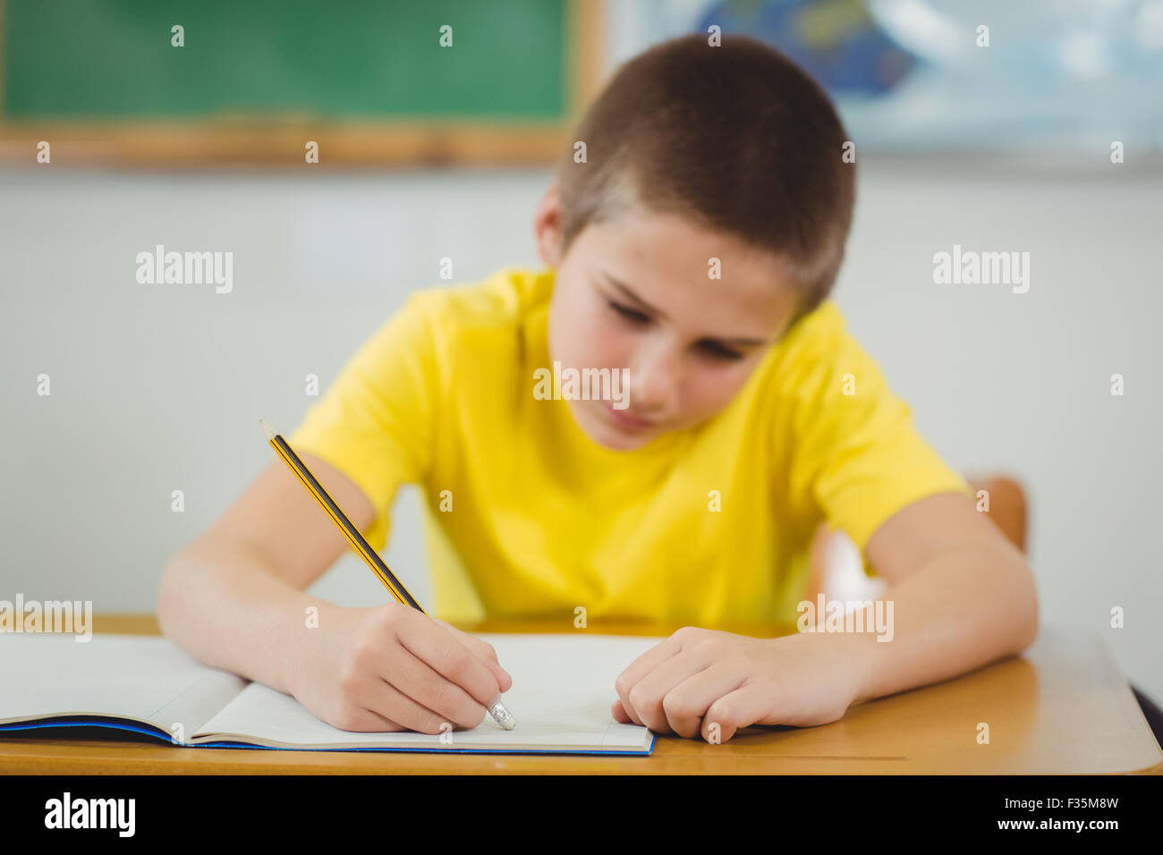 Concentrated pupil working at his desk in a classroom Stock Photo - Alamy