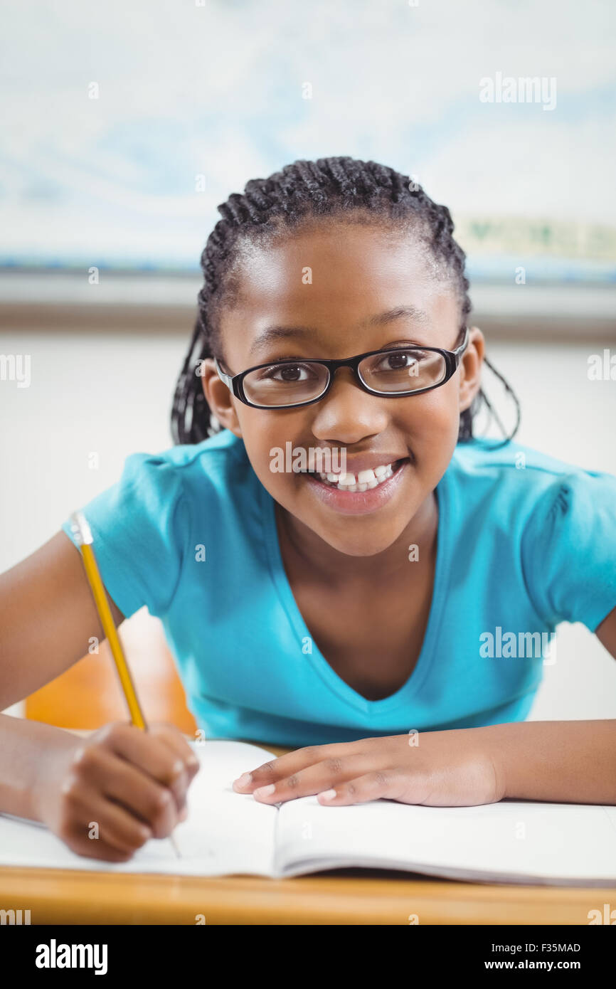 Smiling pupil working at her desk in a classroom Stock Photo - Alamy