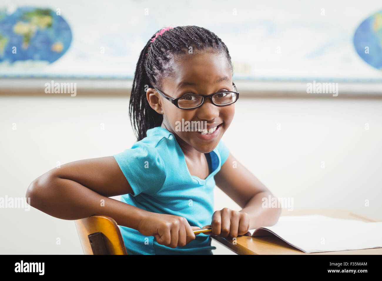 Cute pupil sitting at her desk in a classroom Stock Photo - Alamy
