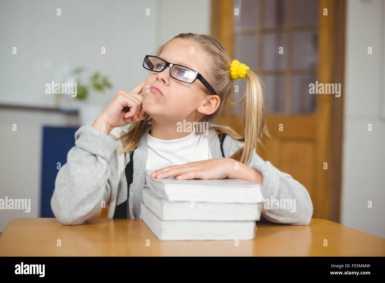 Thoughtful cute pupil sitting at her desk in a classroom Stock Photo ...