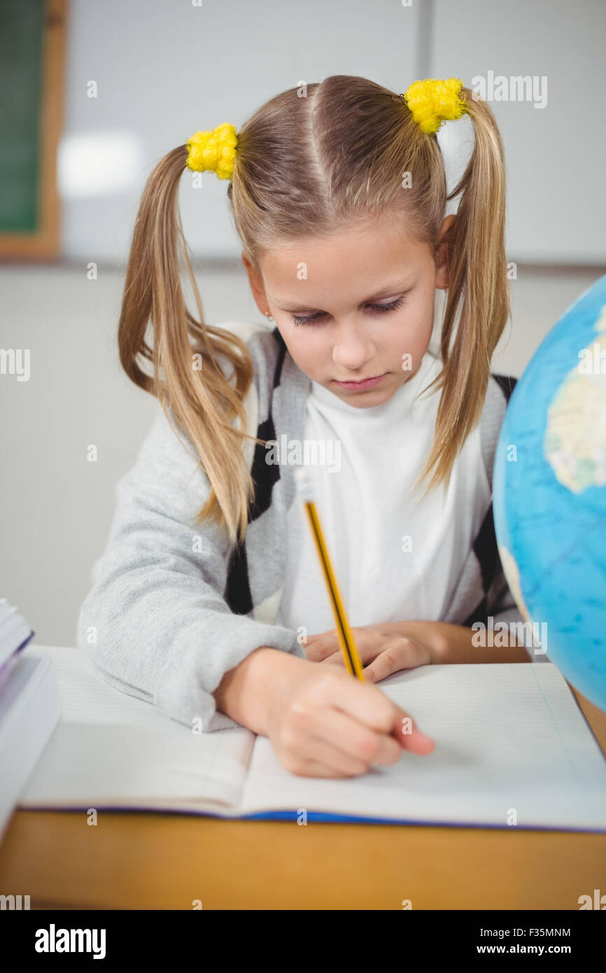 Cute pupil working at her desk in a classroom Stock Photo - Alamy