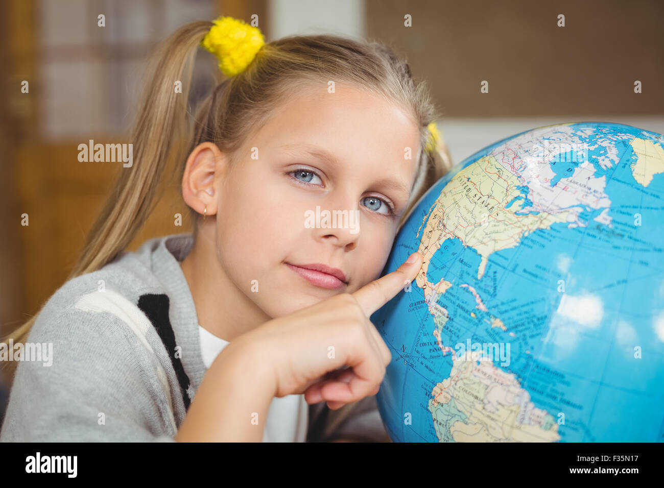 Cute pupil pointing on globe in a classroom Stock Photo - Alamy