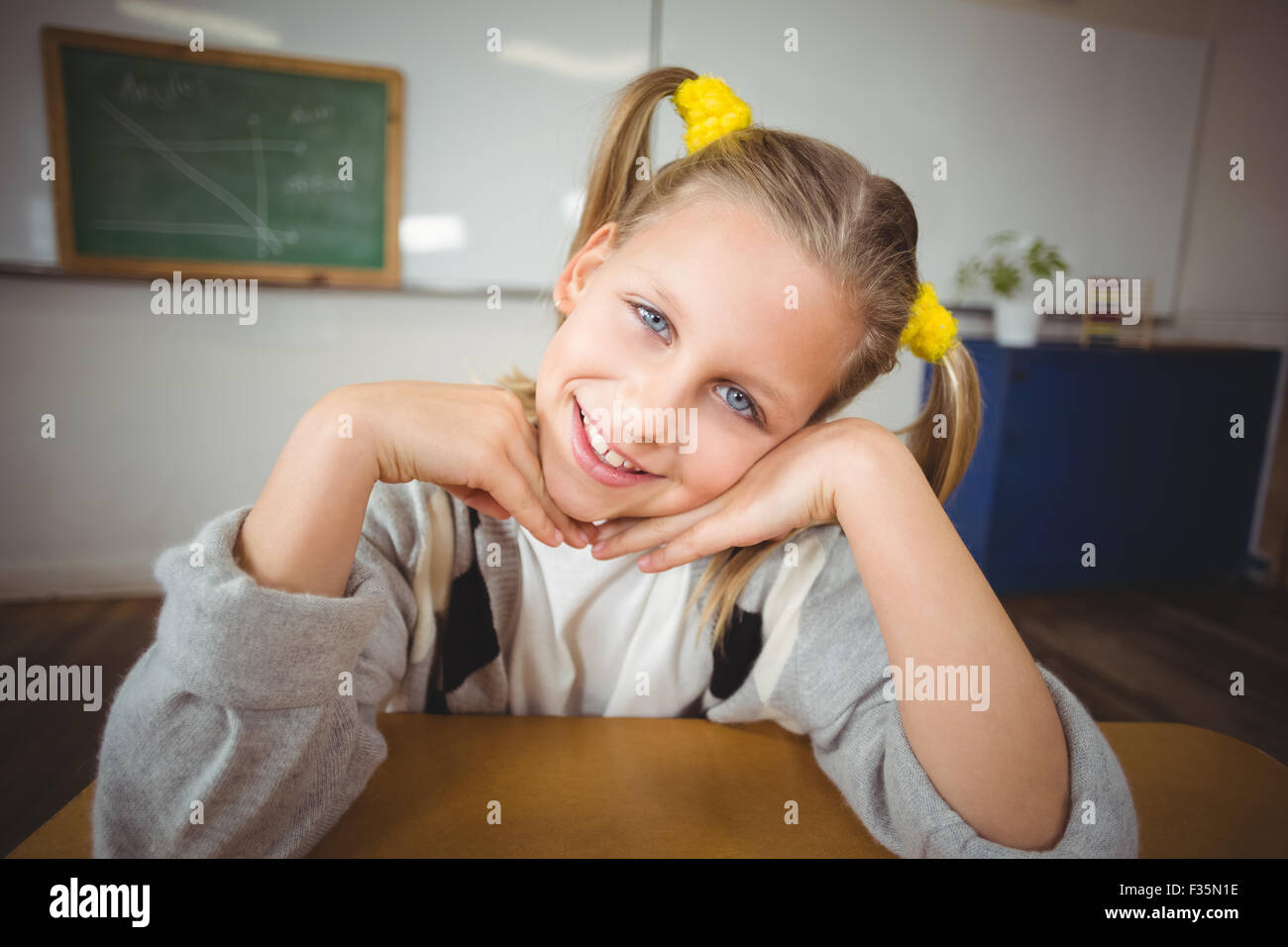 Smiling pupil sitting at her desk in a classroom Stock Photo - Alamy