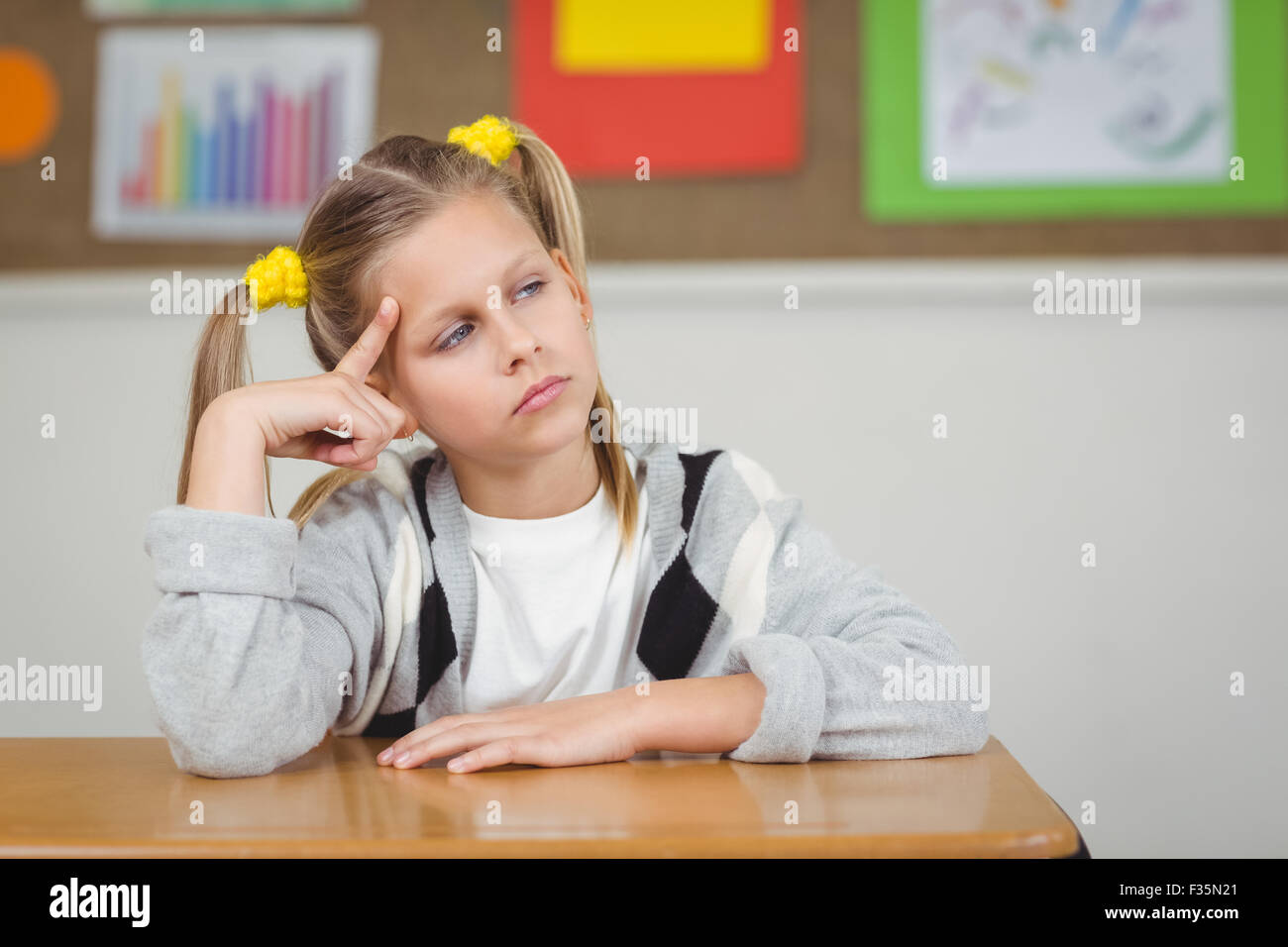 Thoughtful pupil sitting at her desk in a classroom Stock Photo - Alamy