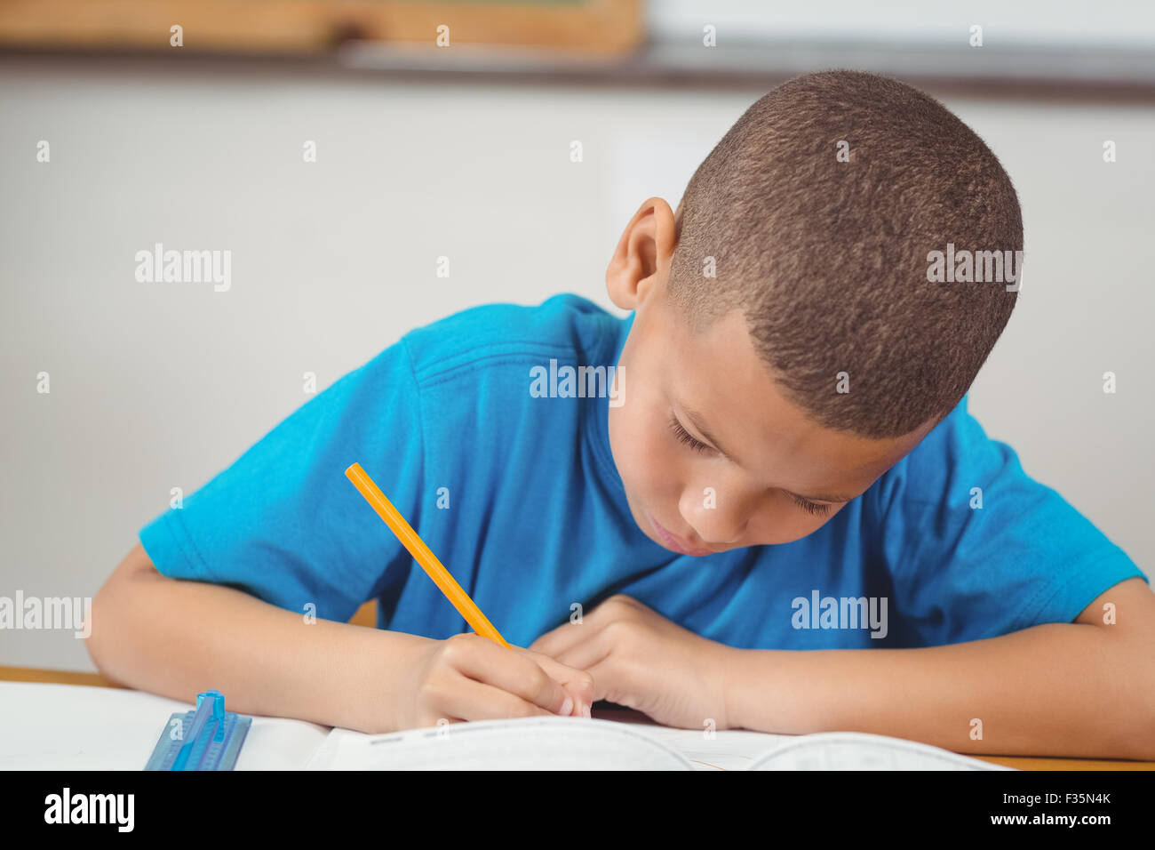 Concentrated pupil working at his desk in a classroom Stock Photo - Alamy