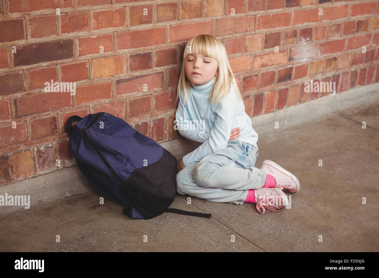 Sad pupil sitting alone on ground Stock Photo - Alamy