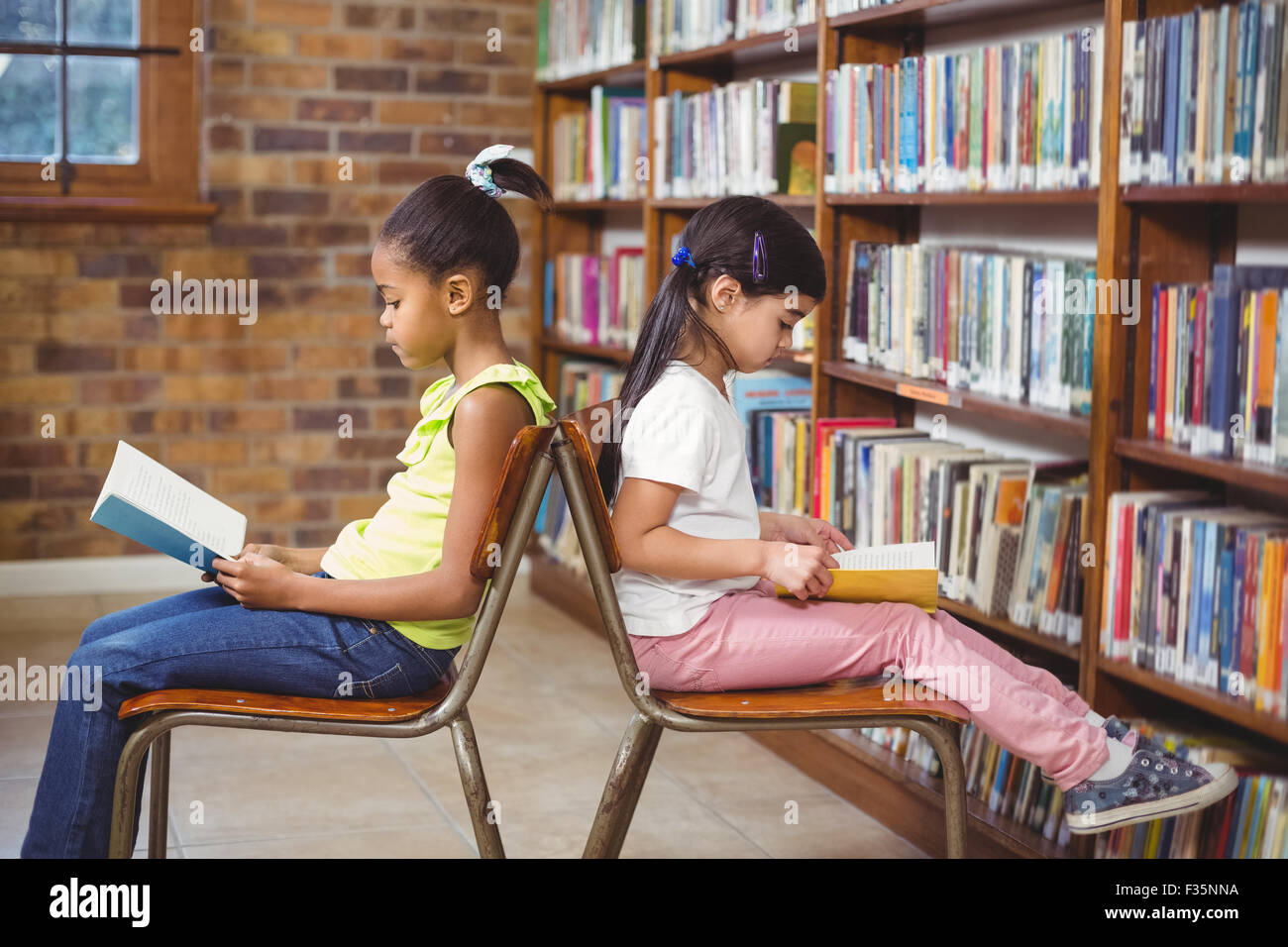 Pupils reading books in the library Stock Photo - Alamy