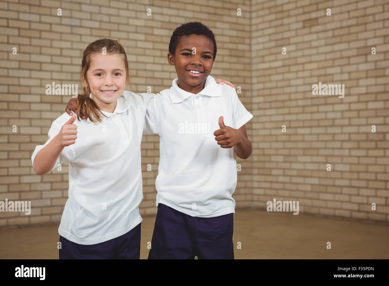 Smiling students with thumbs up Stock Photo - Alamy