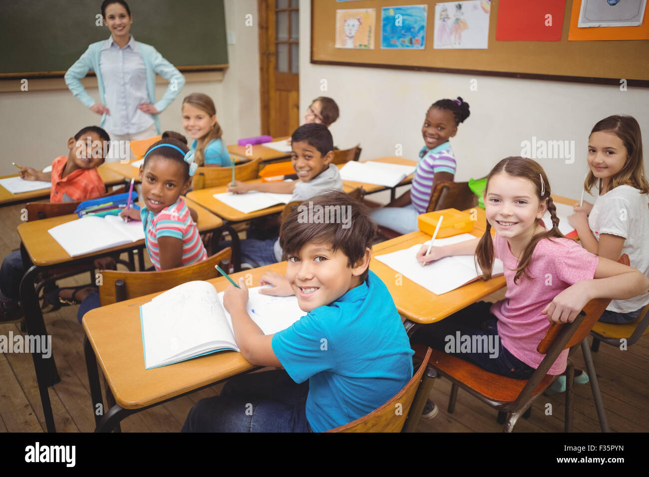 Pupils smiling at camera during class Stock Photo - Alamy