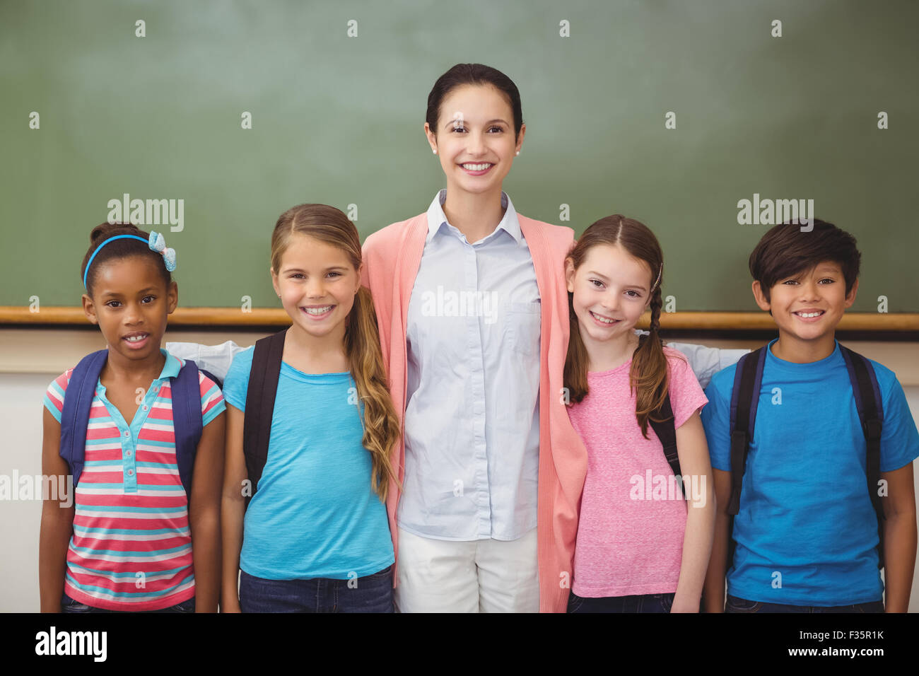 Teacher and pupils smiling at camera in classroom Stock Photo - Alamy
