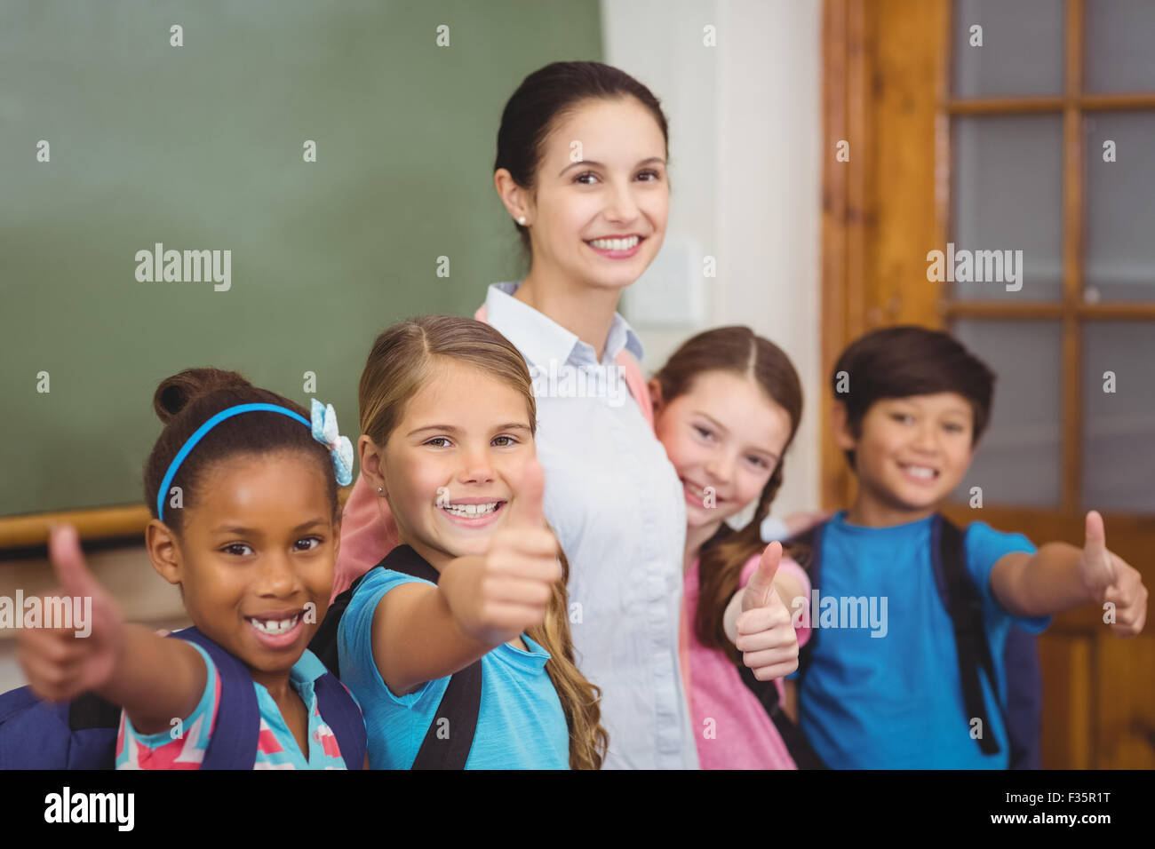 Teacher and pupils smiling in classroom Stock Photo - Alamy