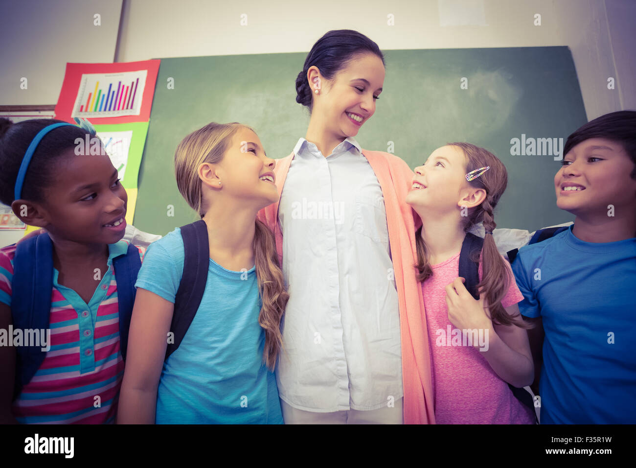 Teacher and pupils smiling in classroom Stock Photo - Alamy