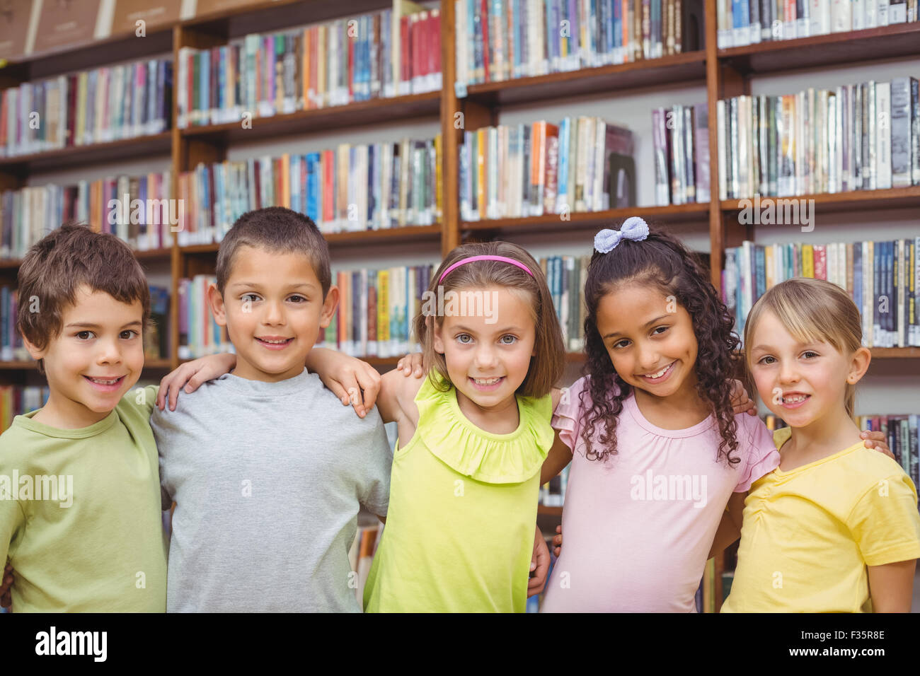 Pupils smiling camera in library hi-res stock photography and images ...