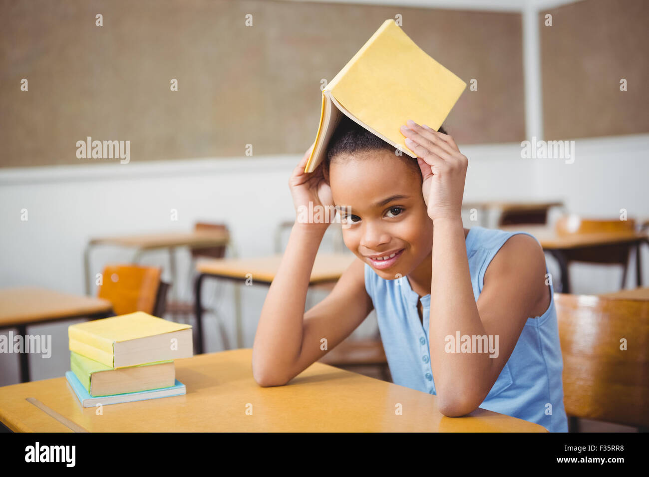 Student holding a book over her head Stock Photo - Alamy