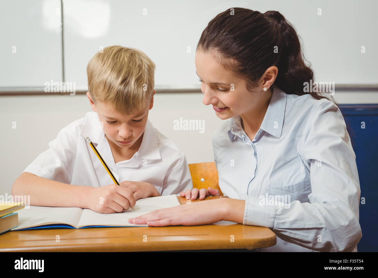 Teacher helping a student in class Stock Photo Alamy