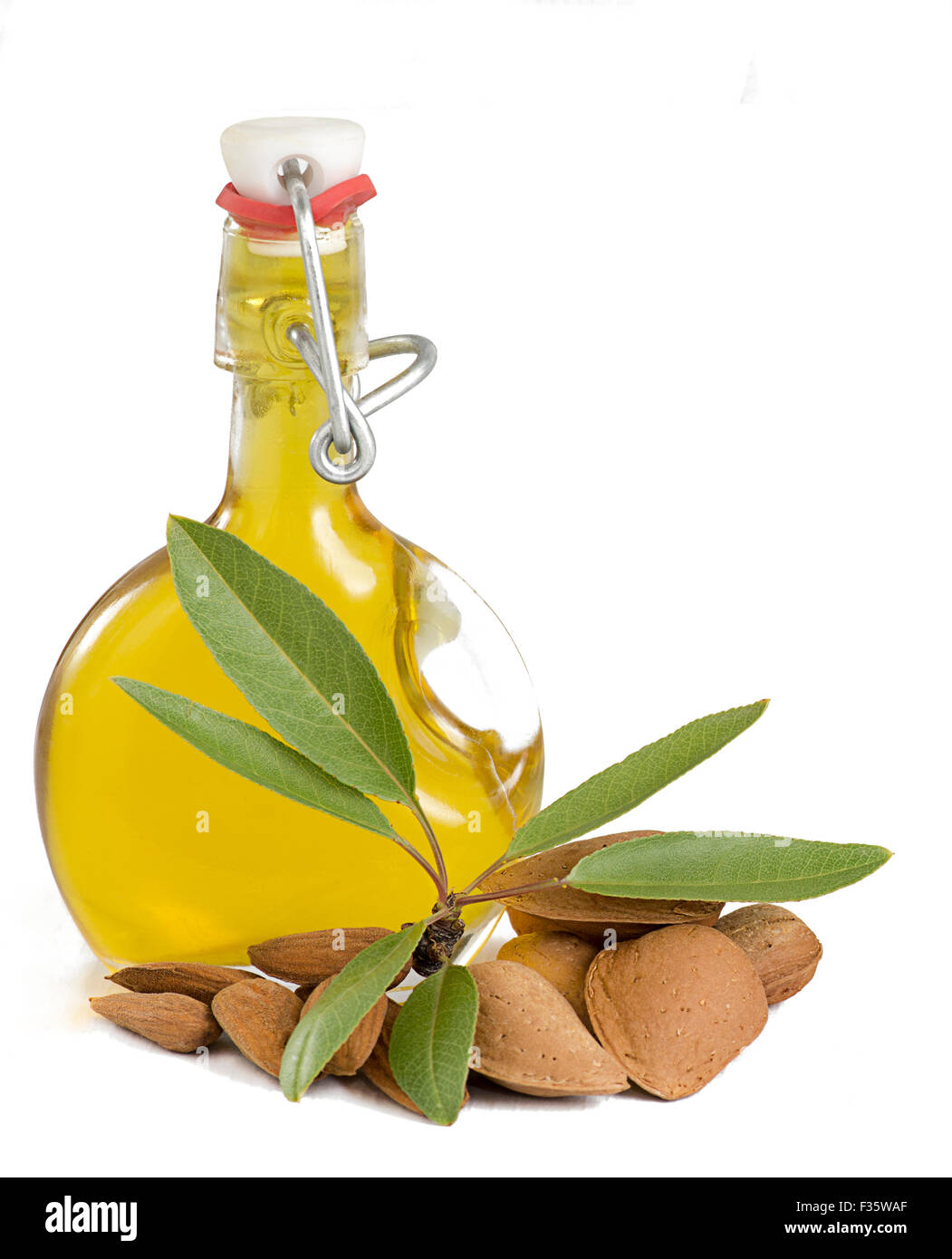 Fresh Almond Oil in a glass bottle showing picked almonds and green