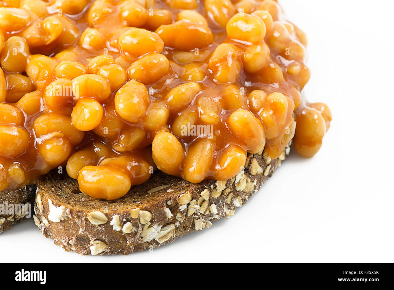 Beans on toast. Selective focus on beans placed on grain toast with a white background leaving room for copy space and text Stock Photo