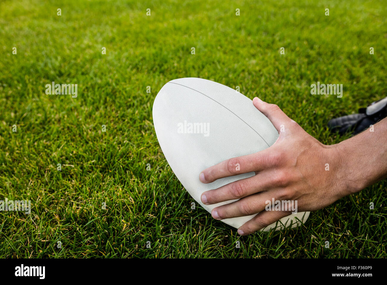 Rugby player picking up ball Stock Photo