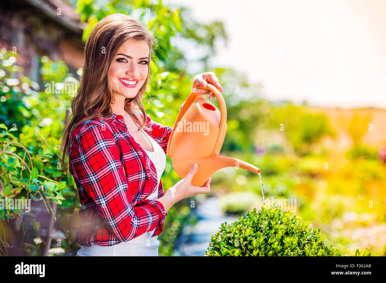 Beautiful young woman gardening Stock Photo - Alamy