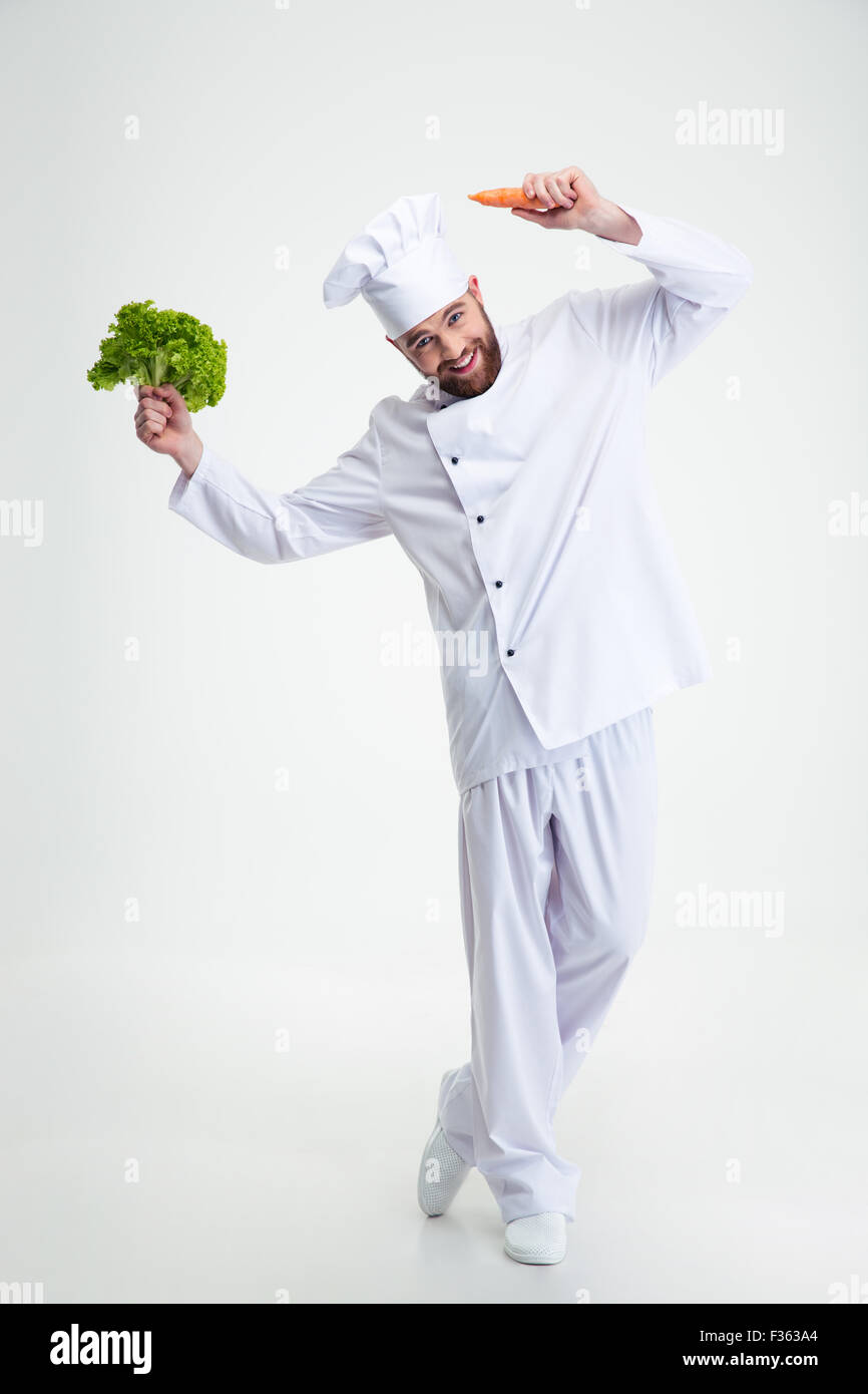 Full length portrait of a happy man dancing with vegetables isolated on