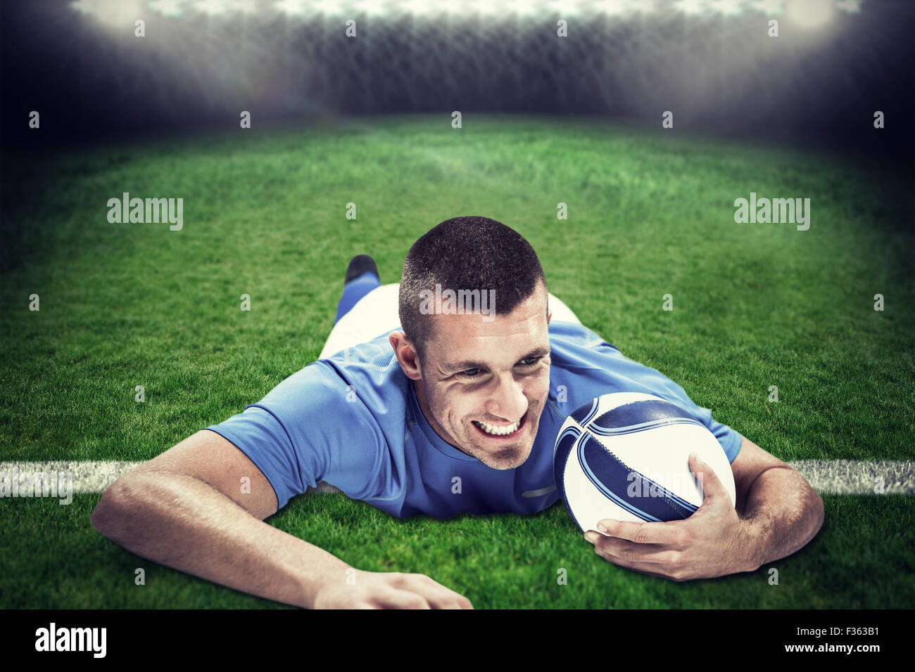 Composite image of confident rugby player lying in front with ball ...