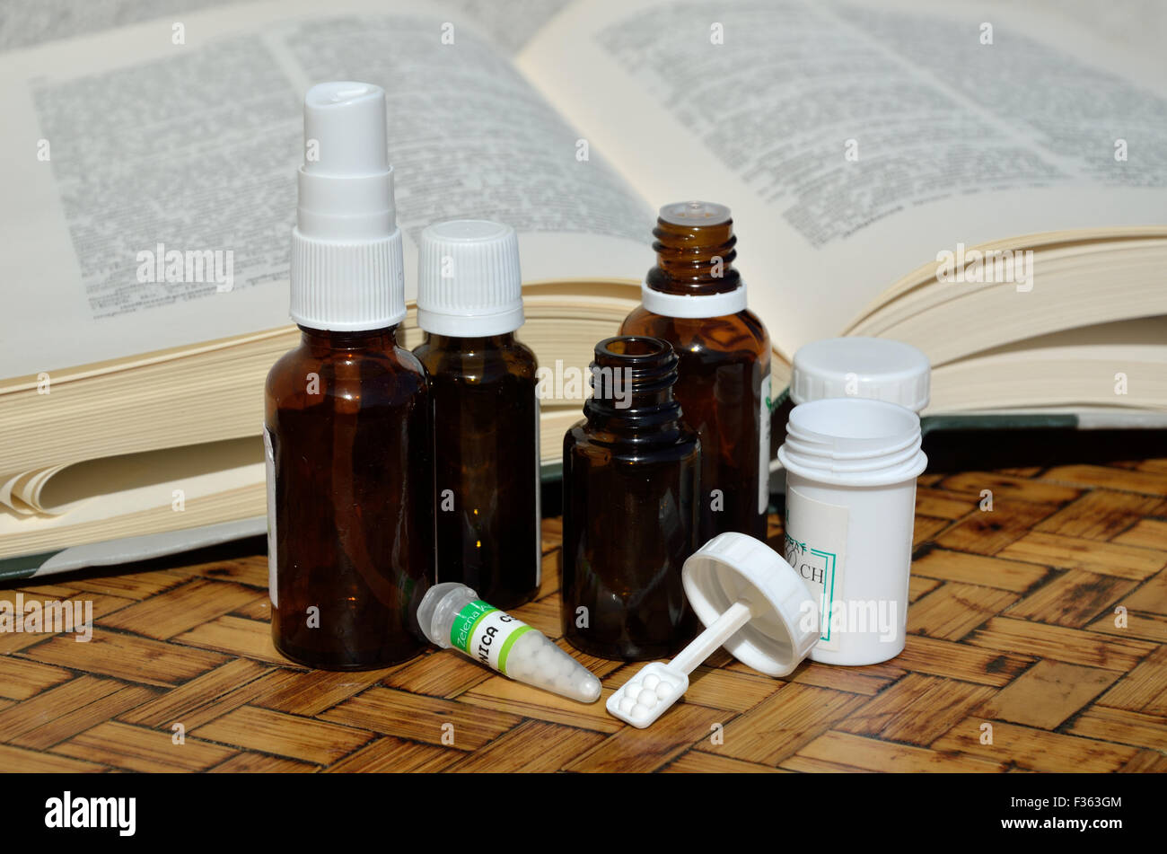 Bottles and containers of homeopathic remedies with a remedy guide book Stock Photo Alamy