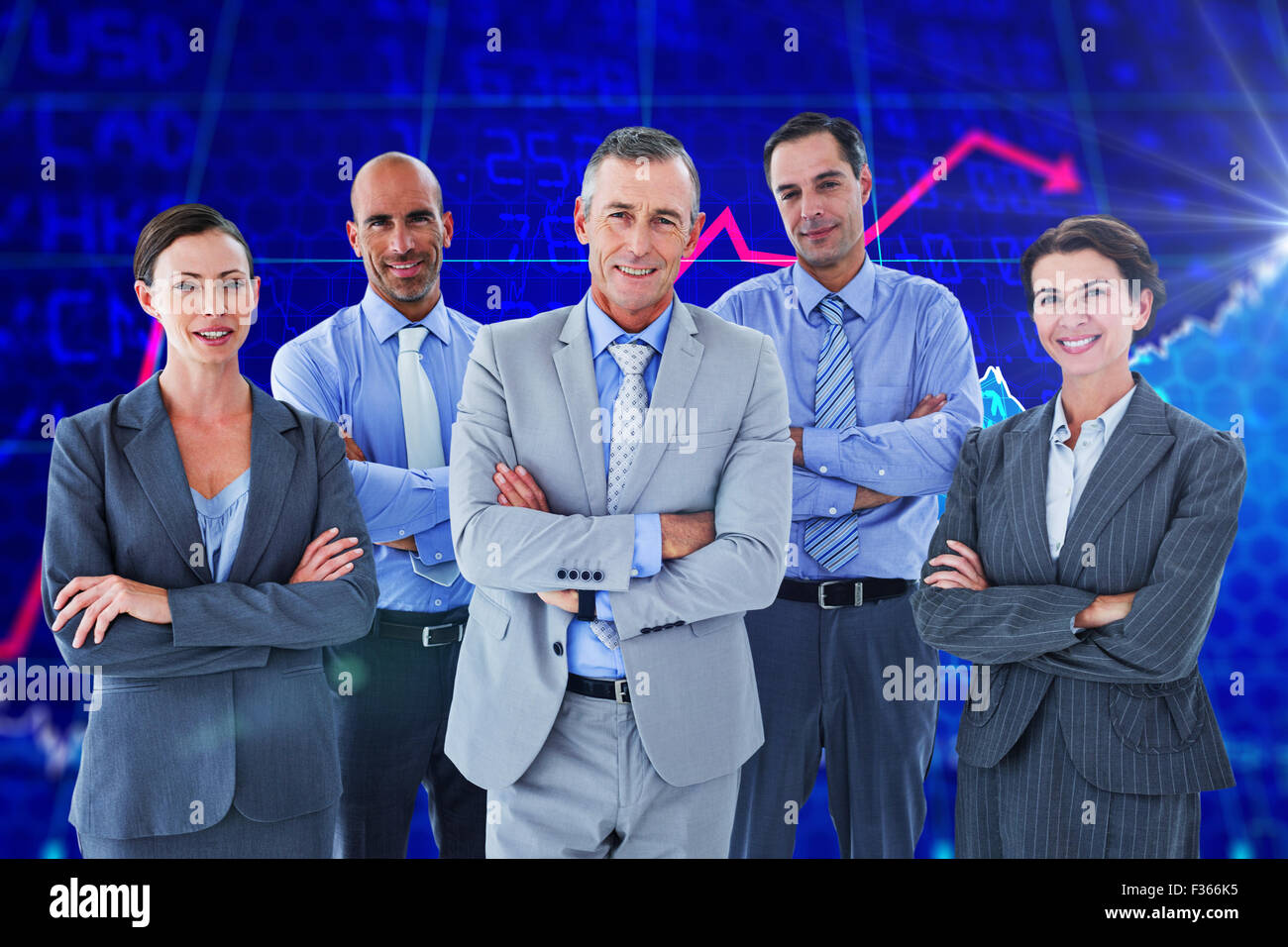 Composite image of business team working happily together on laptop Stock Photo