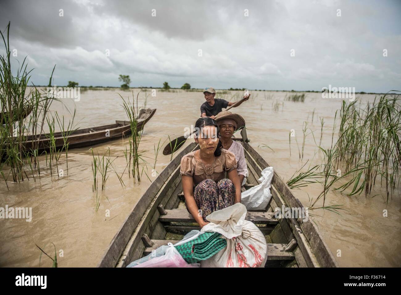 People travel between stilt villages in the flooded Irrawaddy delta, Myanmar. Stock Photo