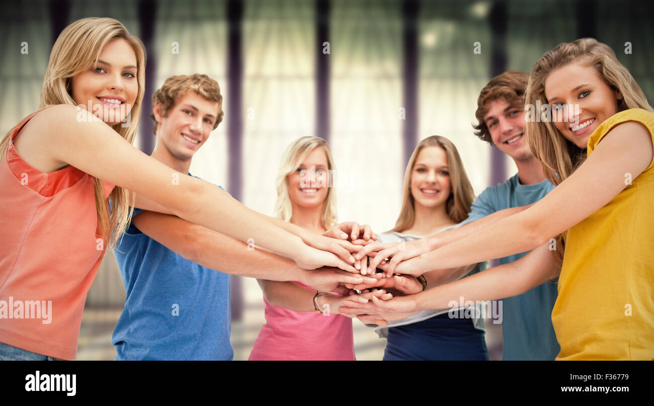 Composite image of low angle shot of friends smiling and looking at the camera Stock Photo