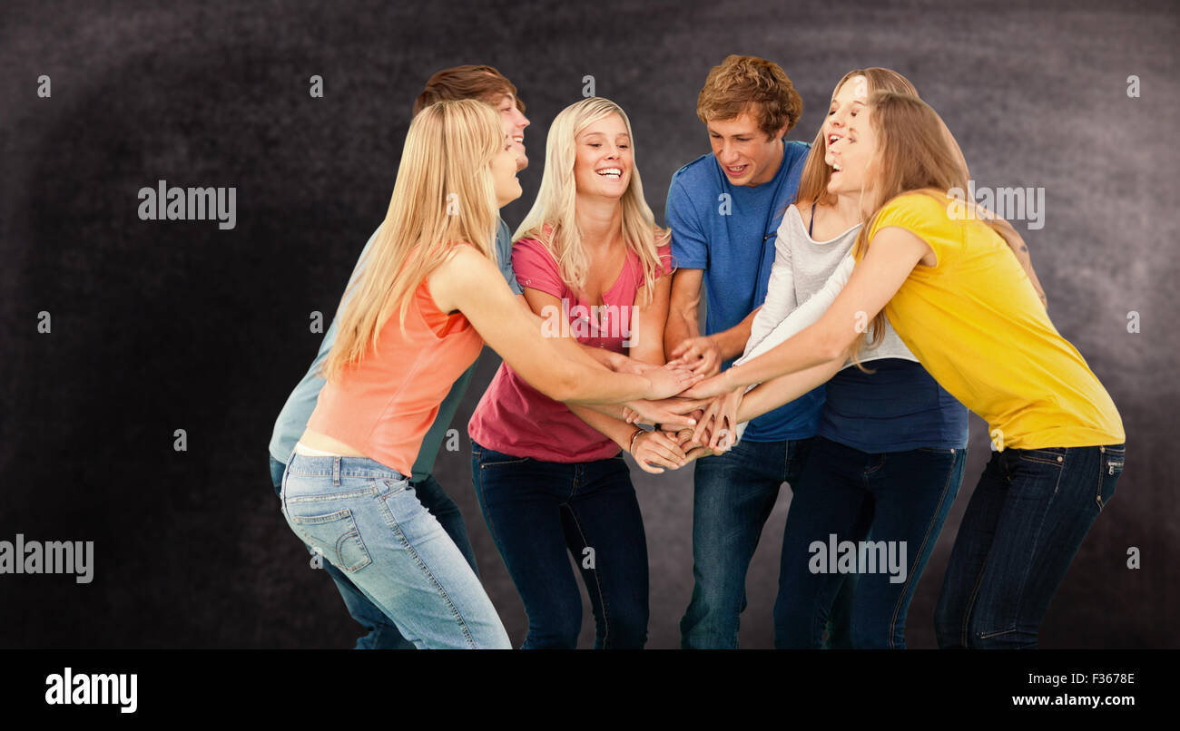 Composite image of group of friends about to cheer with their hands stacked Stock Photo