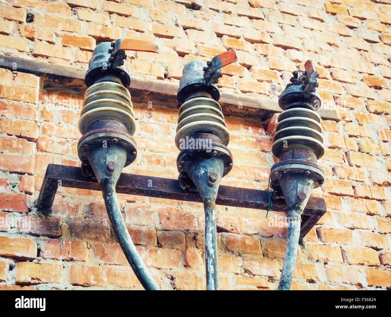 Old fuses on the wall of the brick building. Stock Photo