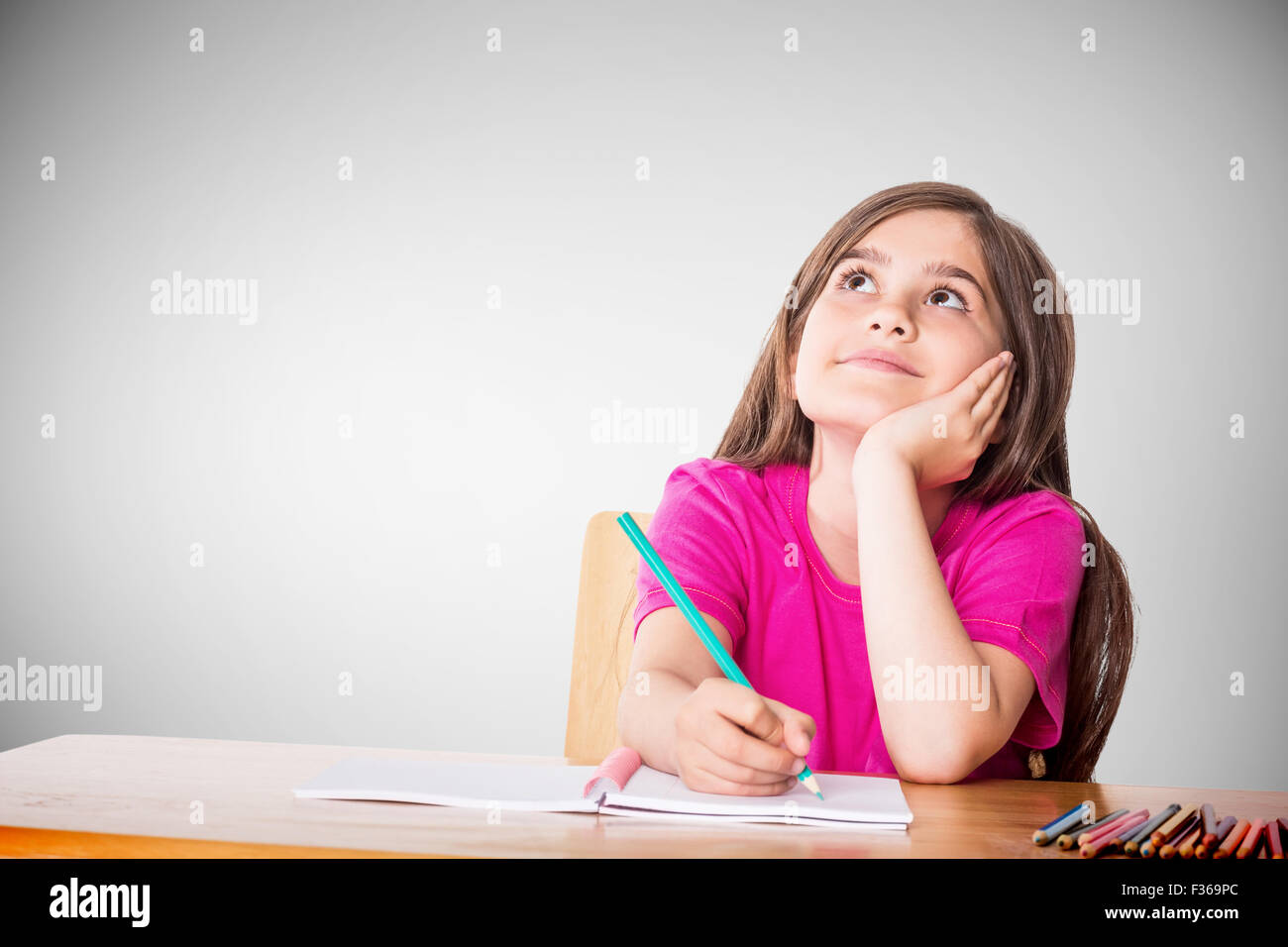 Composite image of cute pupil working at her desk Stock Photo - Alamy