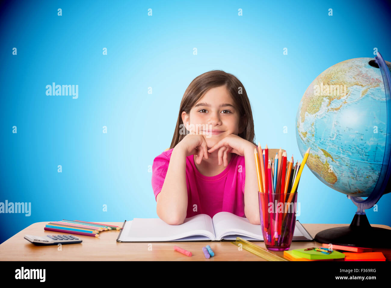 Composite image of cute pupil working at her desk Stock Photo - Alamy